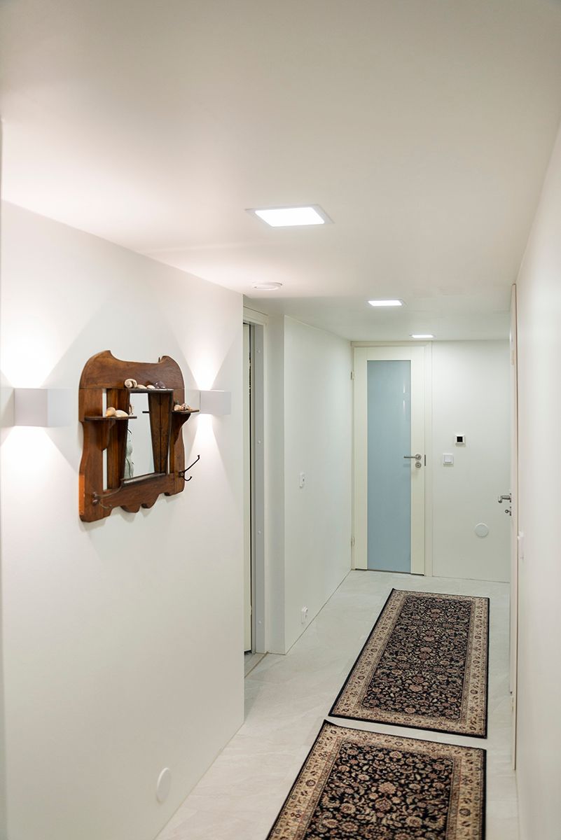 Funk wall lights and recessed led panels in a white hallway.